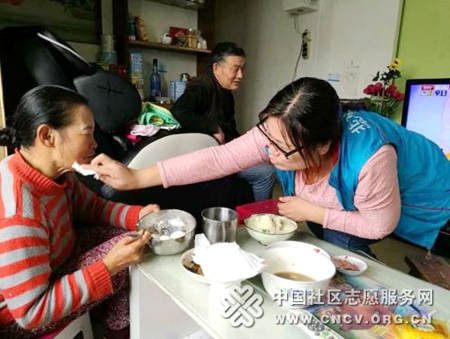 志愿者给马阿姨擦嘴.jpg